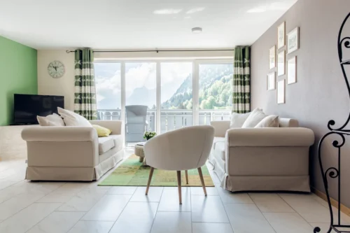 Heller Wohnbereich einer Wildgrün Lodge mit Sofa, Esstisch und Küche